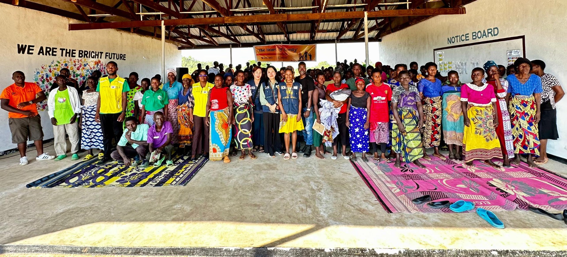A large community gathering in a Malawian village hall during an outreach programme